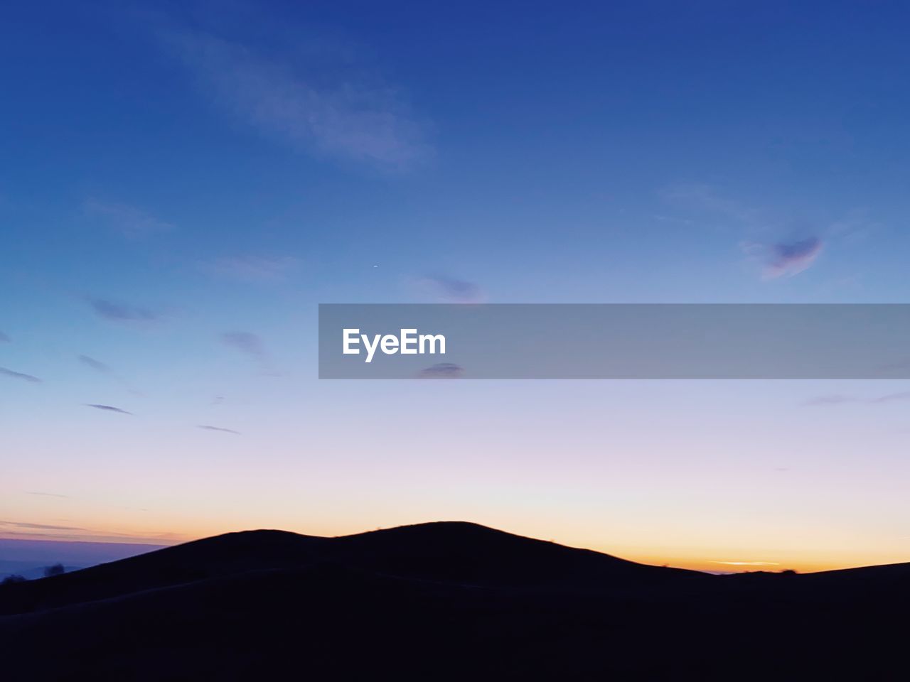 Scenic view of silhouette mountains against sky at sunset