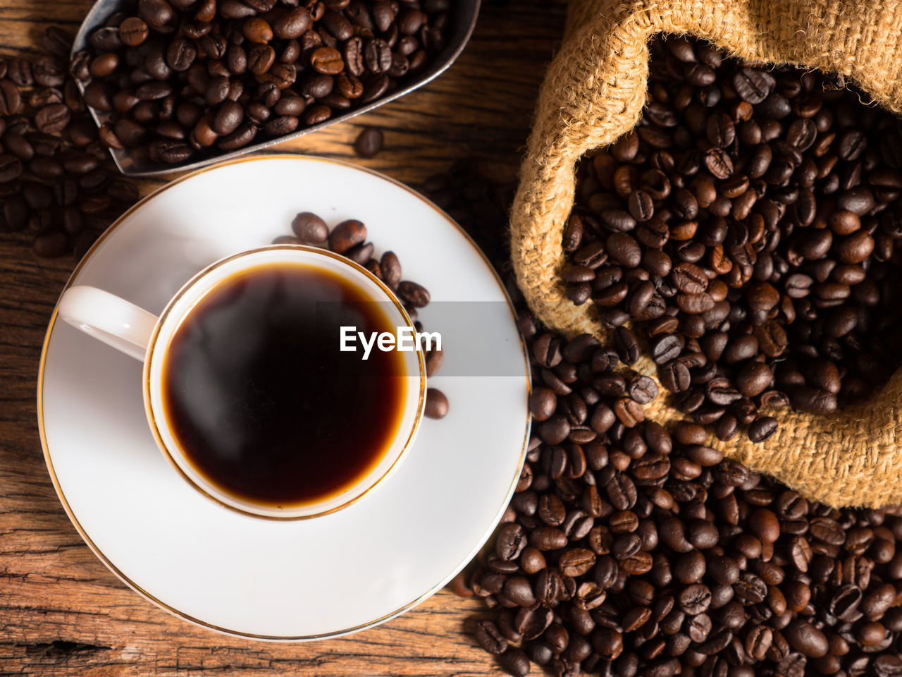 food and drink, coffee, roasted coffee bean, cup, drink, food, mug, coffee cup, refreshment, brown, black coffee, freshness, hot drink, crockery, saucer, indoors, table, dark, wood, still life, no people, directly above, studio shot, scented, high angle view, black, seed, cafe, coffee break, roasted, close-up, coffee crop, healthy eating