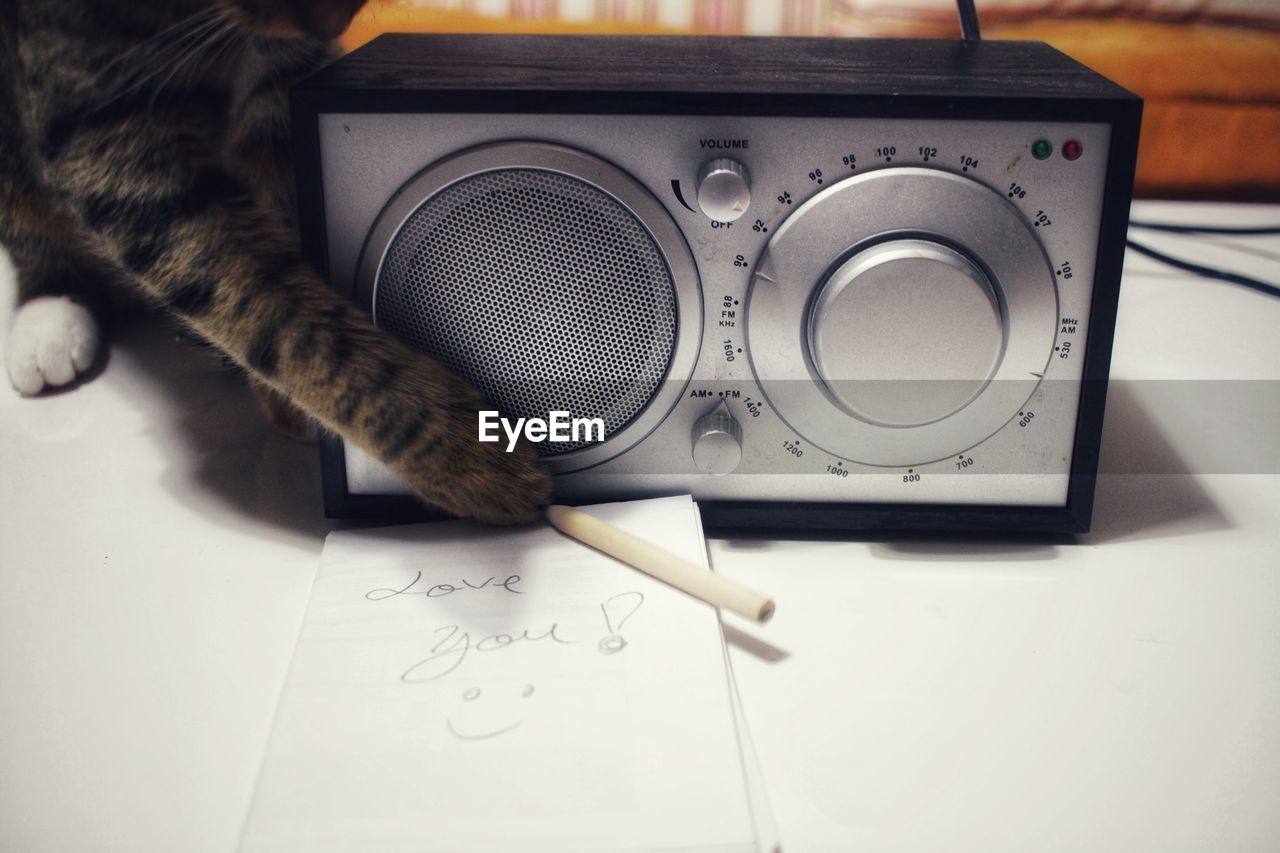 Close-up of love message near a radio and a cat on table