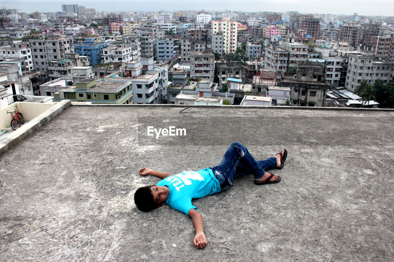 High angle view of boy lying on building terrace