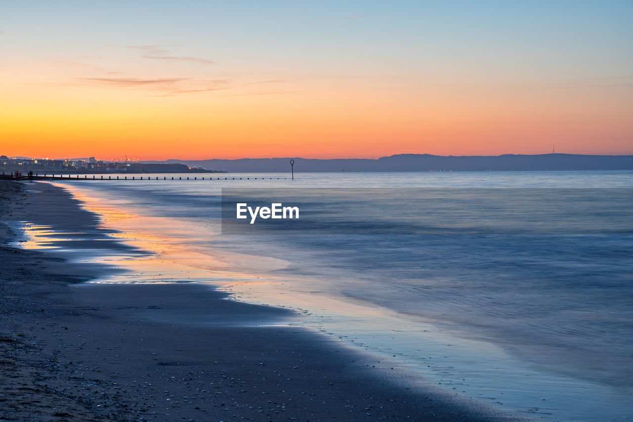 Scenic view of beach against sky during sunset