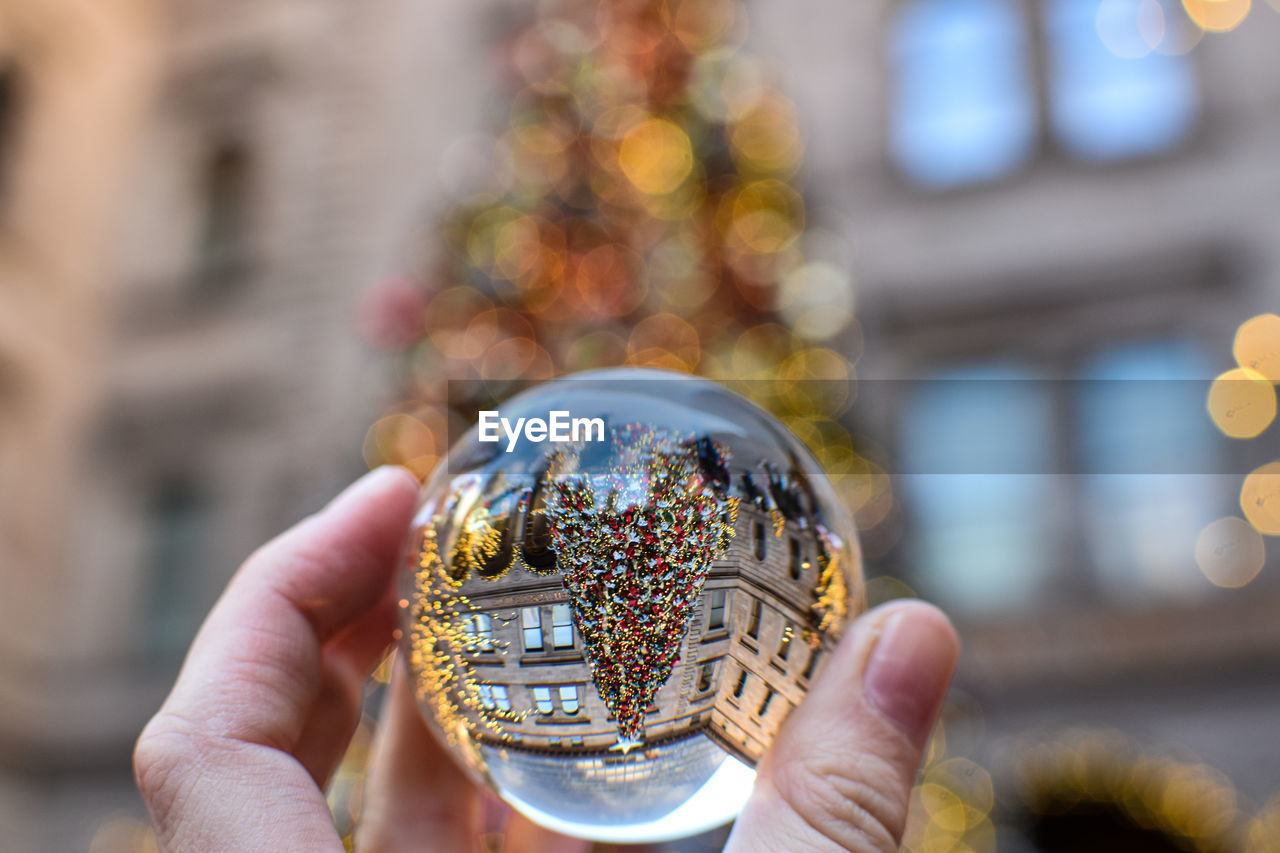 hand, holding, one person, yellow, focus on foreground, christmas tree, close-up, architecture, adult, city, gold, celebration, outdoors, decoration, christmas, day, travel destinations, nature