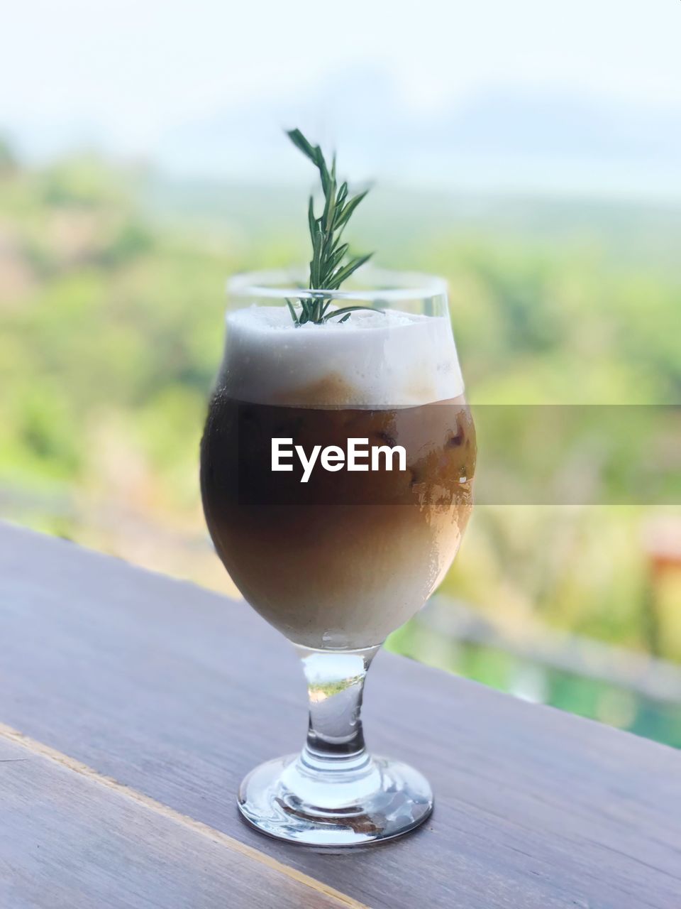 CLOSE-UP OF DRINK ON GLASS TABLE