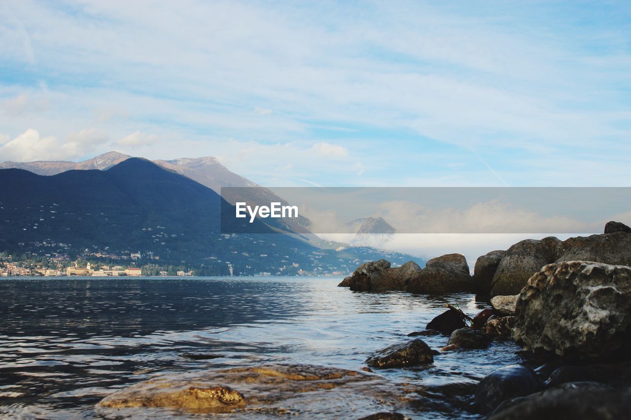 Scenic view of sea and mountains against sky