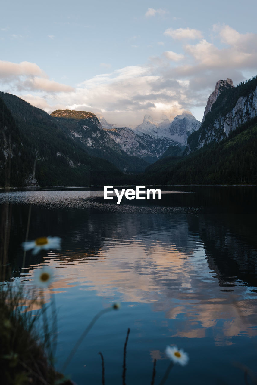 scenic view of lake by mountains against sky