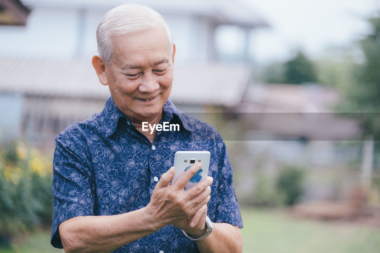 MID ADULT MAN USING SMART PHONE