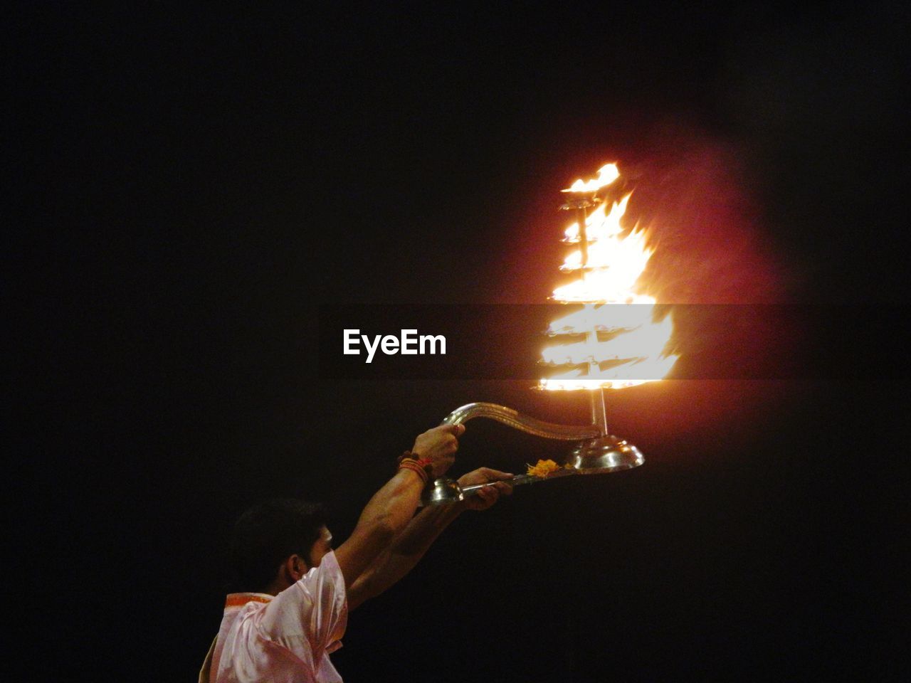 PEOPLE HOLDING LIT CANDLES IN DARK