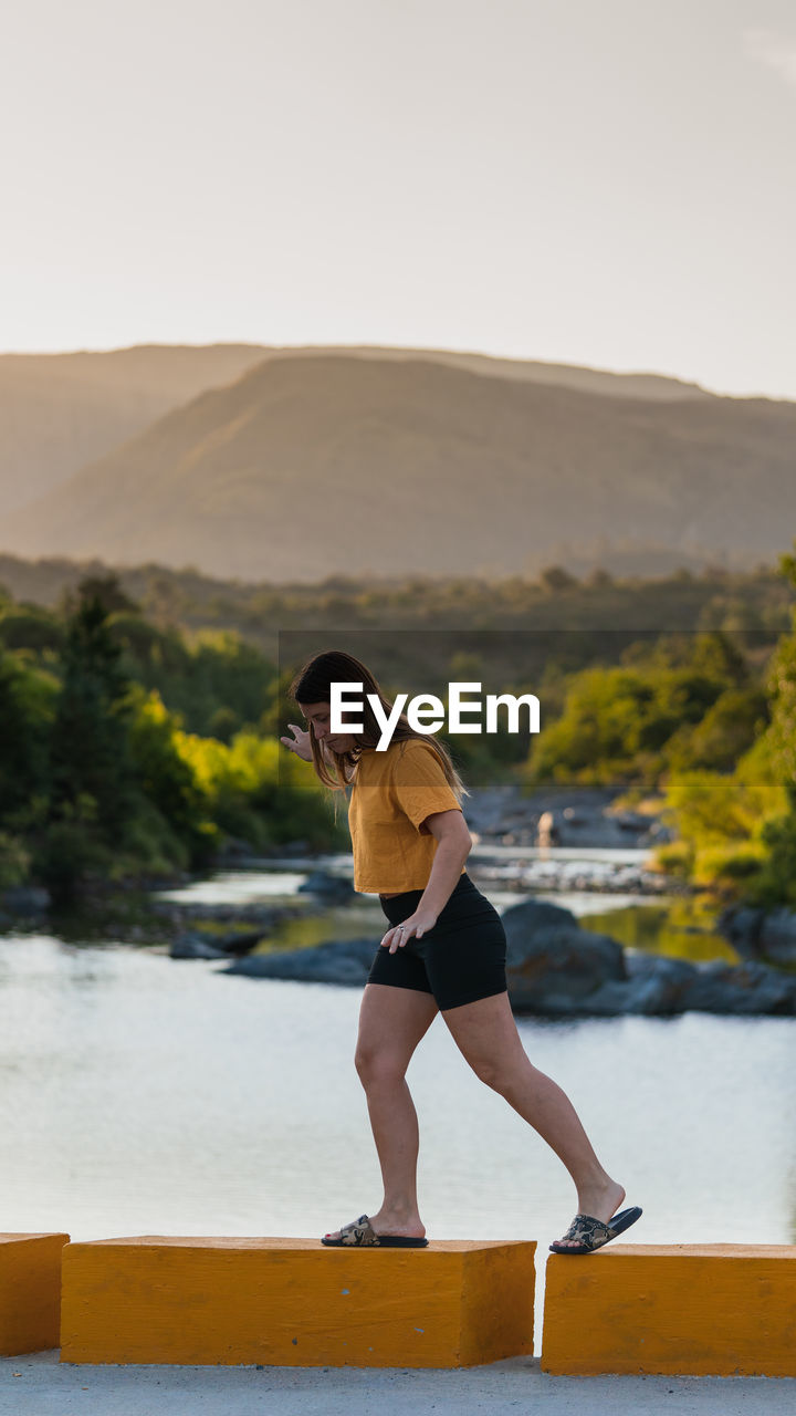 Full length of woman walking against tree