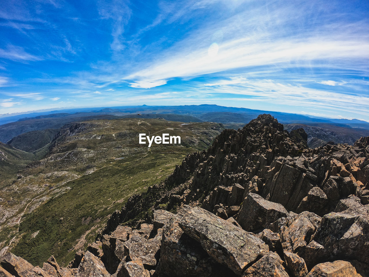 AERIAL VIEW OF LANDSCAPE BY MOUNTAINS AGAINST SKY