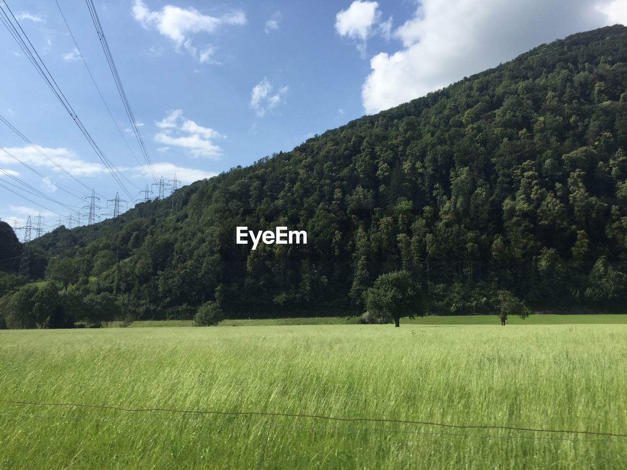 Scenic view of river with trees and mountains against cloudy sky