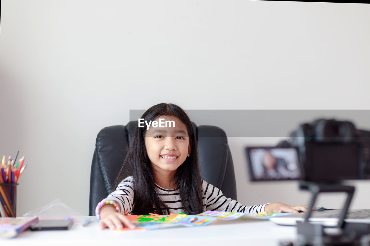 Portrait of smiling girl sitting on chair