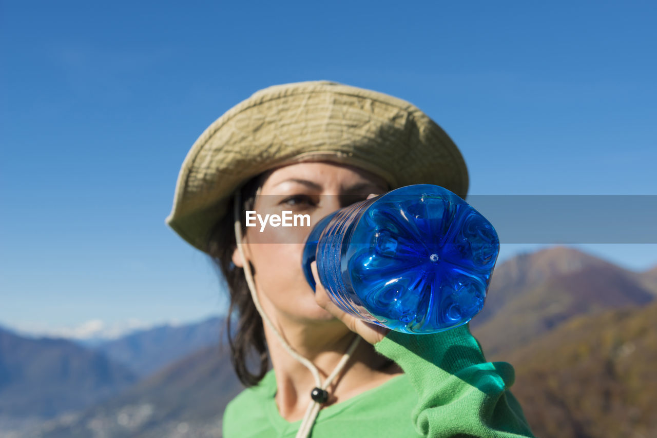 Close-up of young woman against clear blue sky