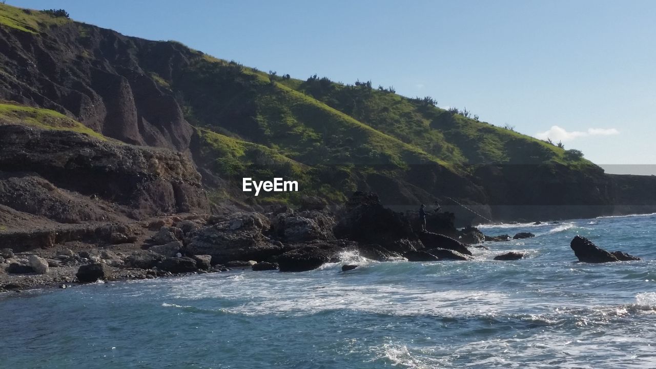 SCENIC VIEW OF SEA AND MOUNTAIN AGAINST CLEAR SKY