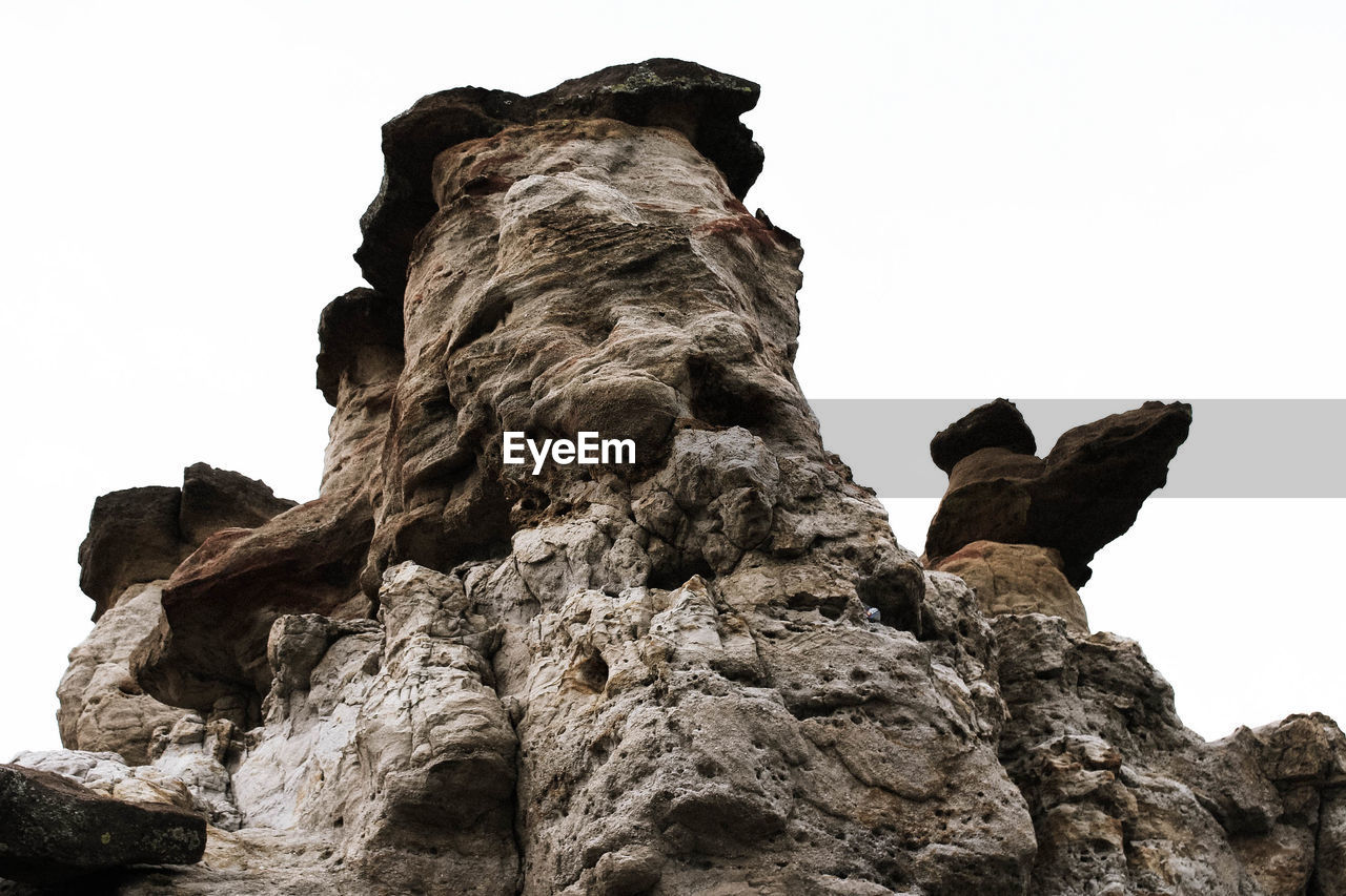 LOW ANGLE VIEW OF ROCKS AGAINST CLEAR SKY