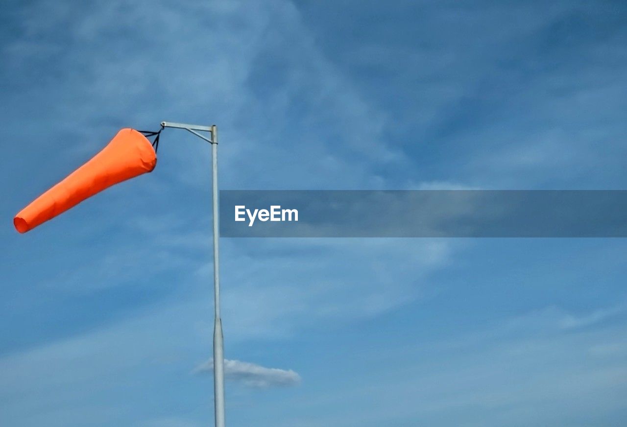 sky, blue, cloud, wind, low angle view, nature, day, no people, outdoors, flag, street light, copy space, pole, environment, red