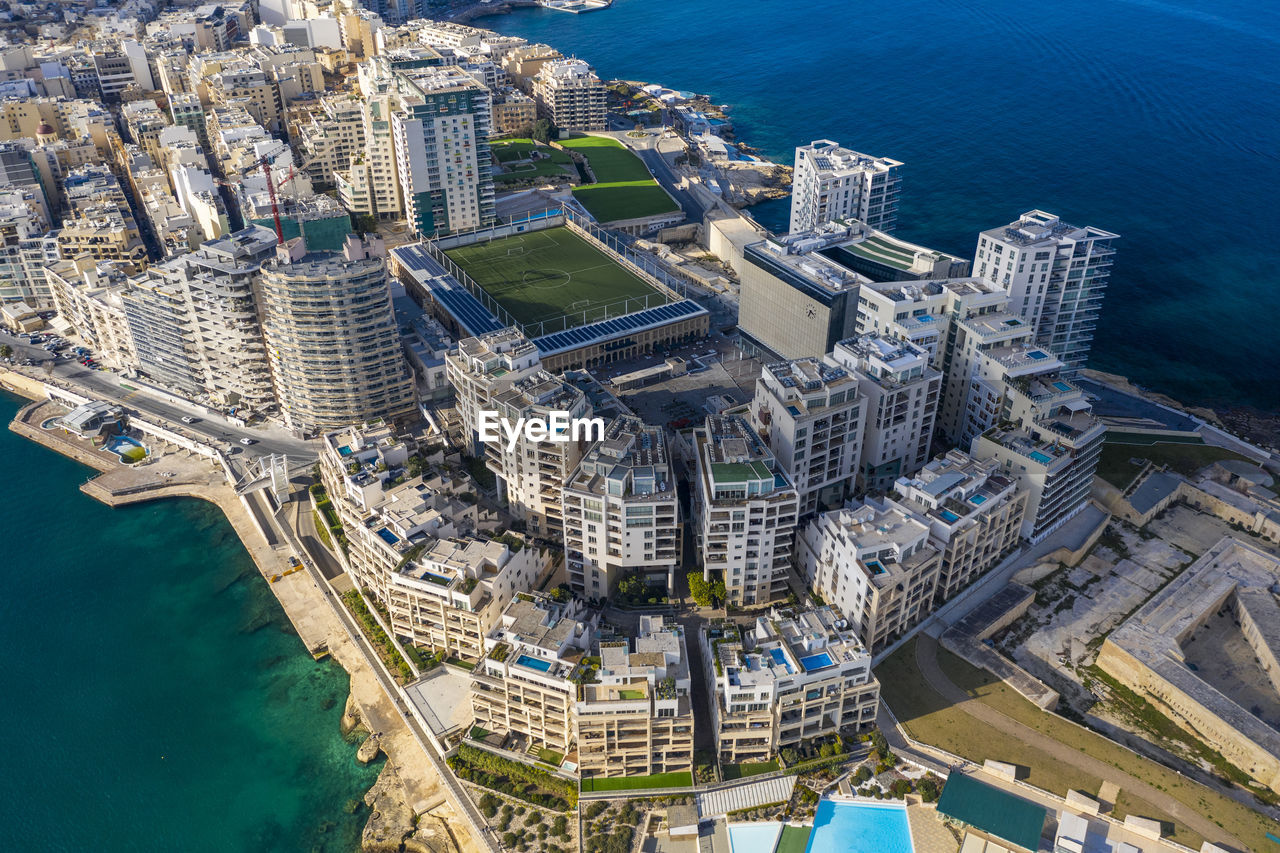 Malta, central region, sliema, aerial view of soccer field, apartments and hotels of tigne point peninsula