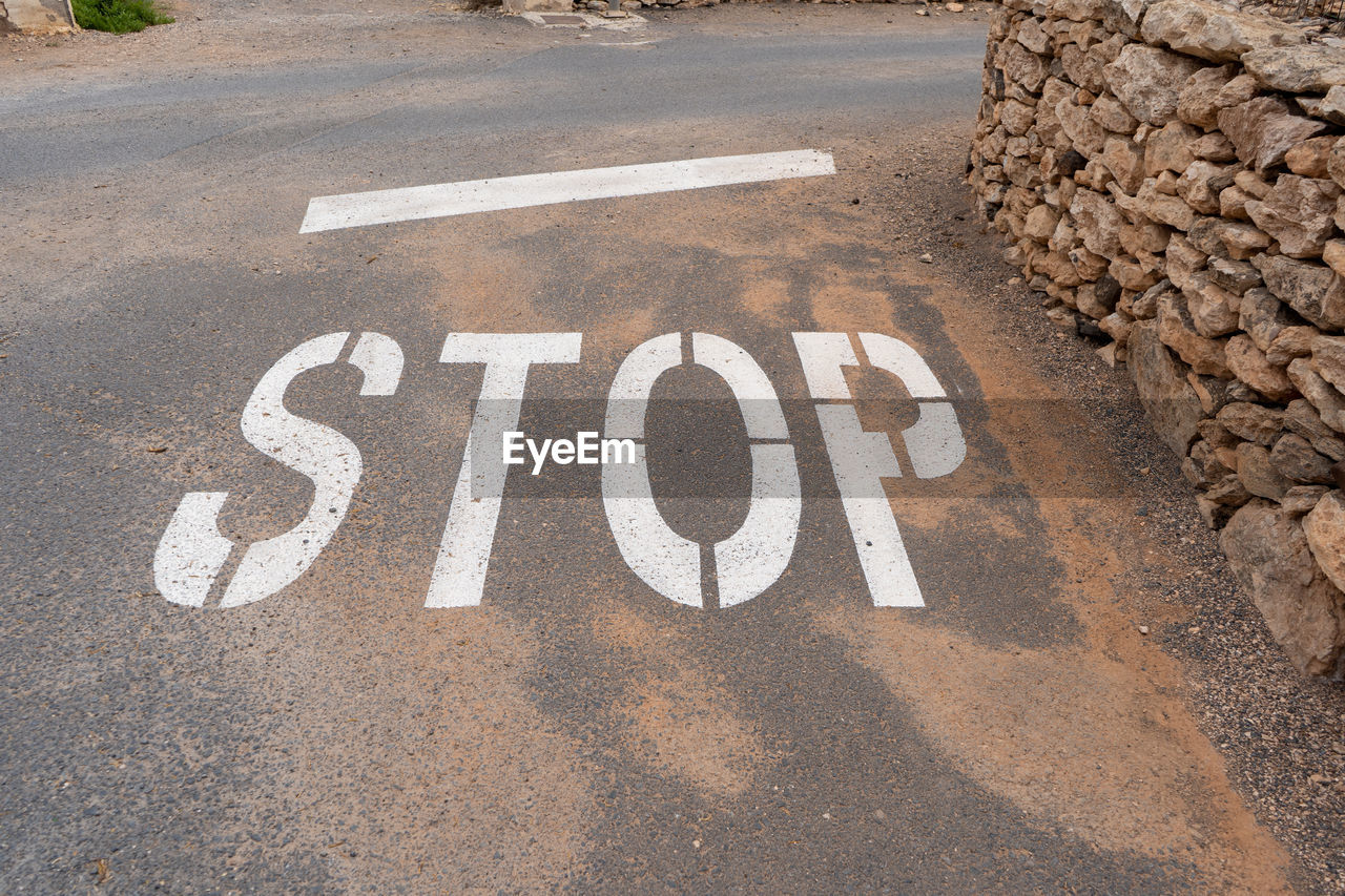 HIGH ANGLE VIEW OF SIGN ON ROAD