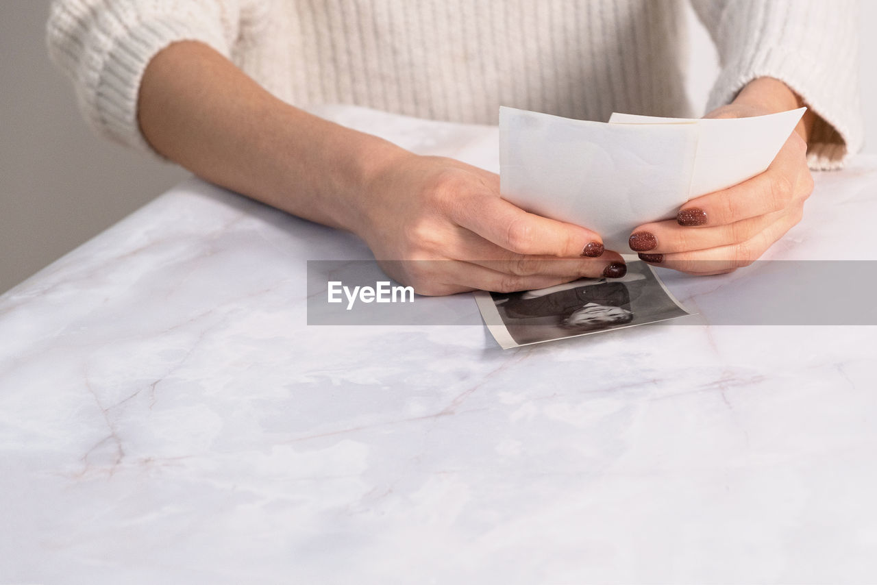 Woman looking at printed photos, remember nostalgia for a day of rest. photography cards