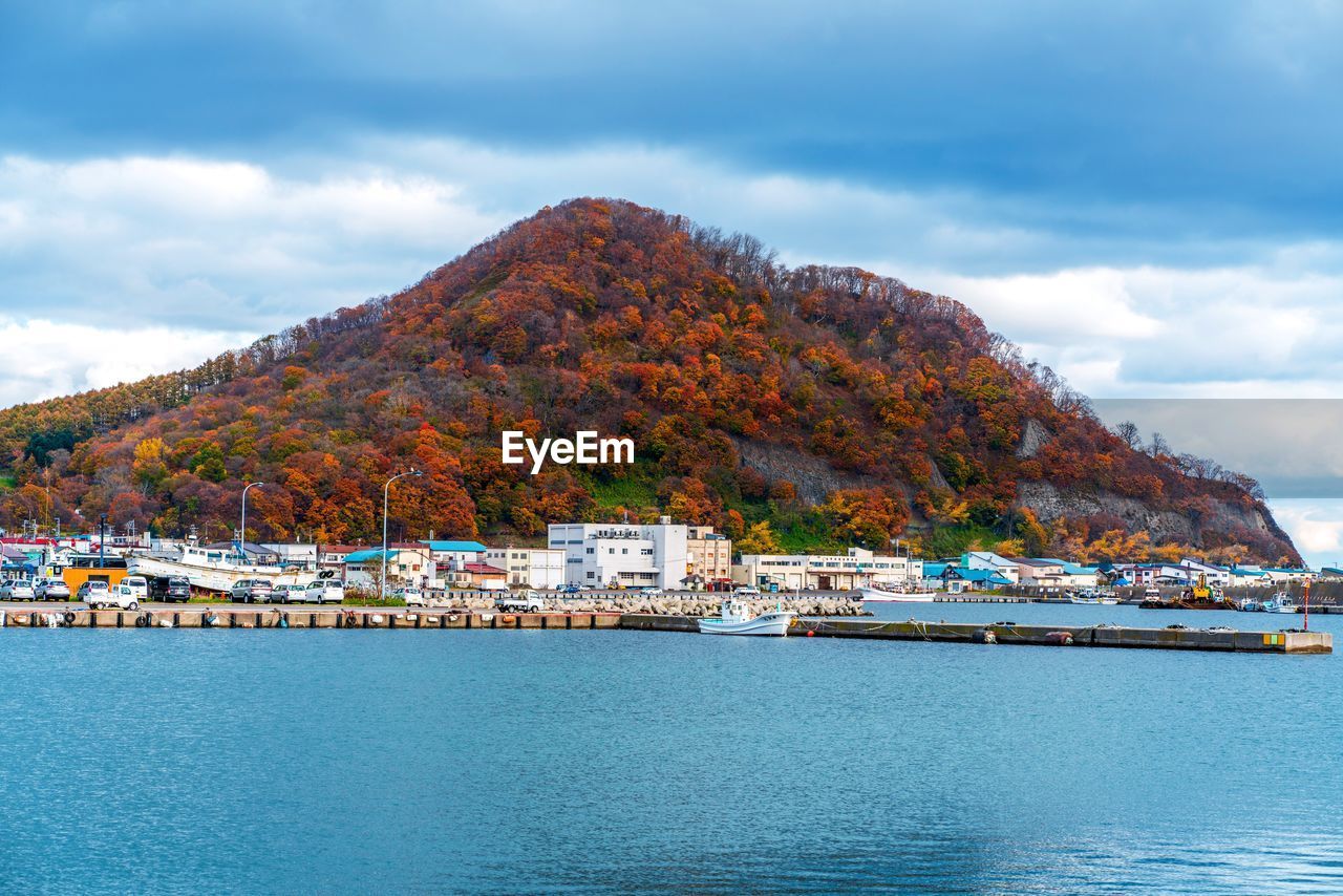 Scenic view of sea by buildings against sky