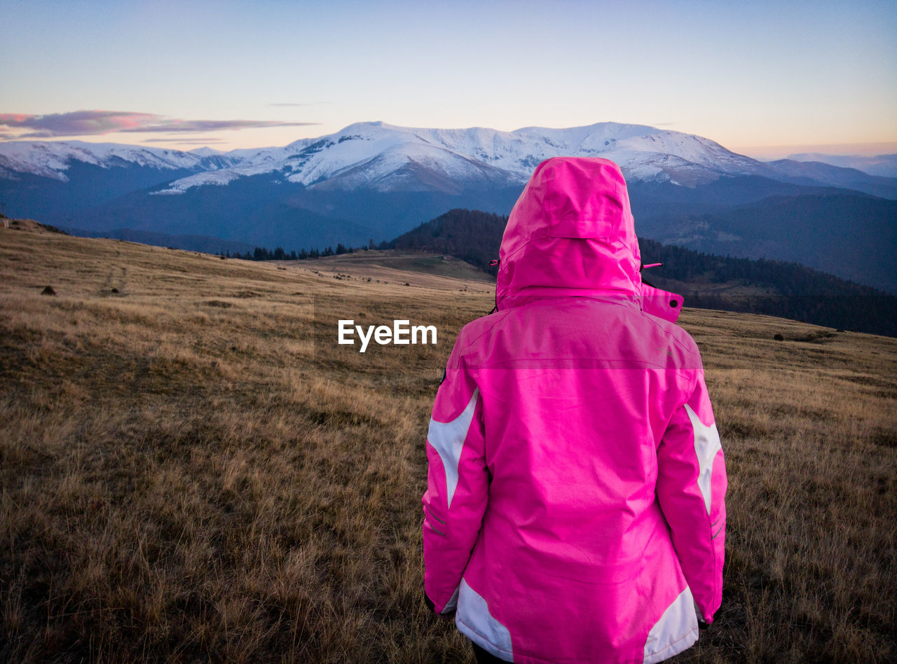 Rear view of woman on field against mountains