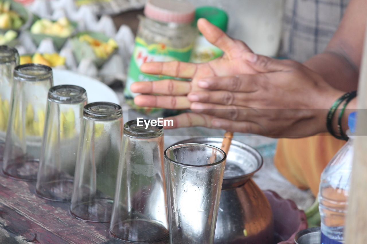 Cropped hands of woman preparing drink for sale