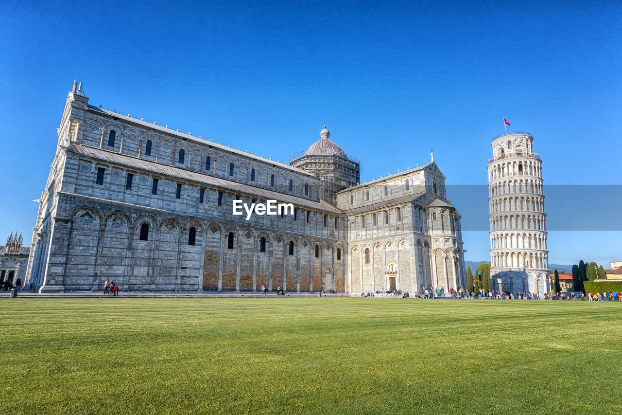 Lawn in front of building against blue sky