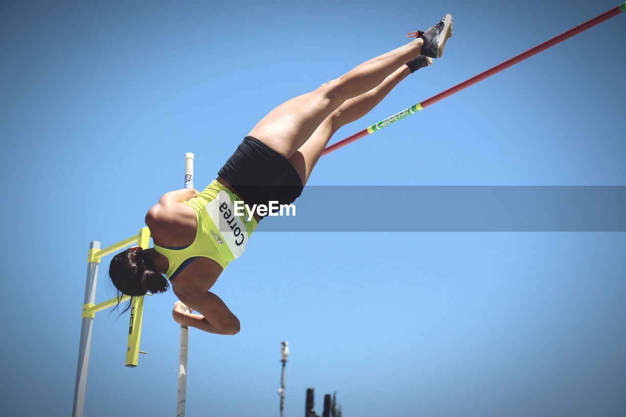 LOW ANGLE VIEW OF MAN HOLDING ROPE AGAINST SKY