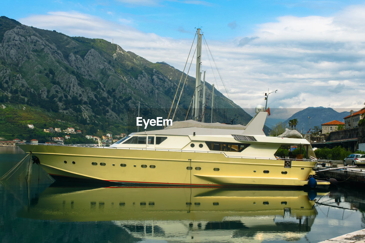 Motor yacht moored in the bay. in the background of the mountain and the blue sky with clouds
