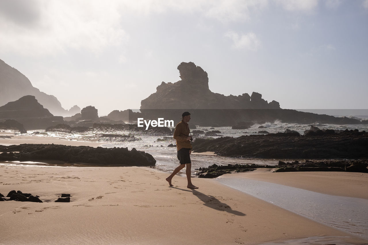 Rear view of man walking at beach