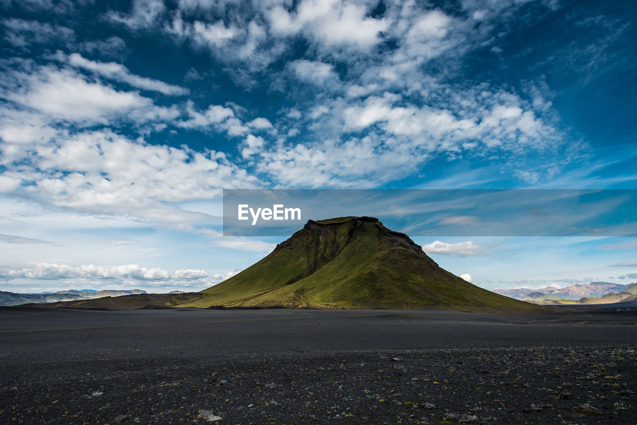 Scenic view of mountains against cloudy sky