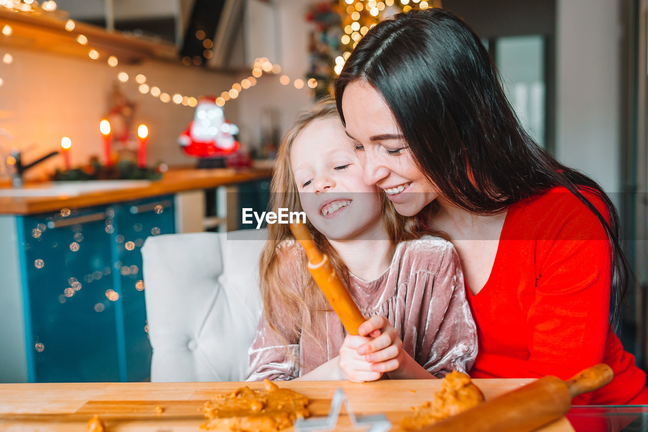 Happy mother and daughter on table