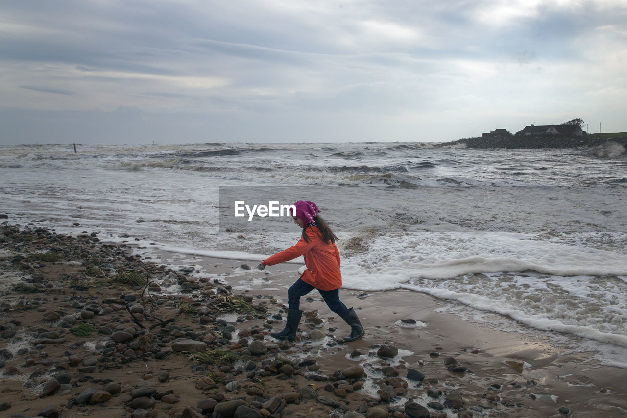 Full length of girl walking on shore at beach