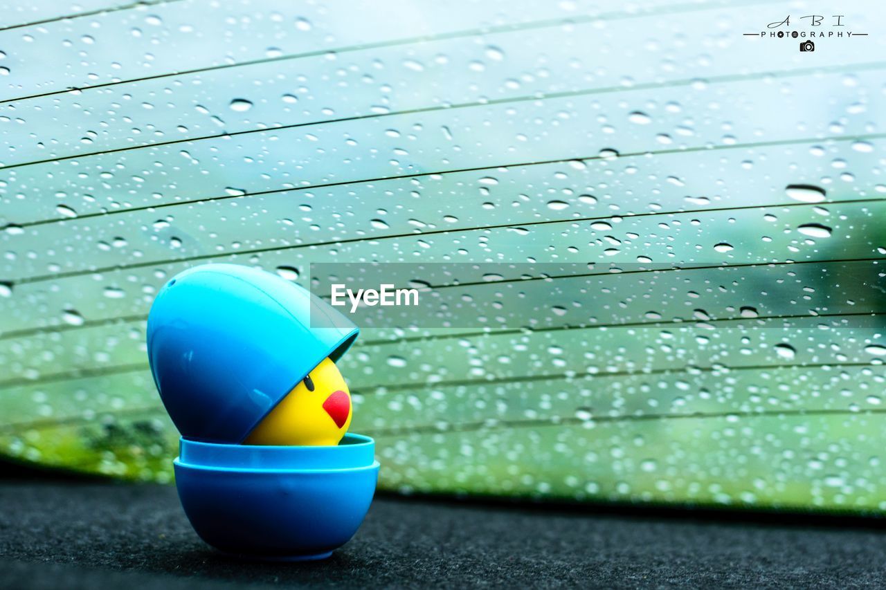 CLOSE-UP OF RAINDROPS ON BLUE UMBRELLA