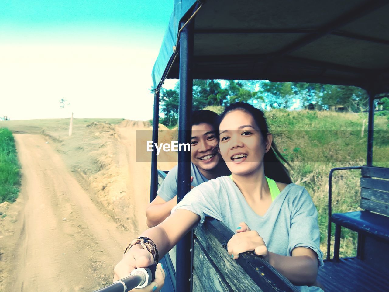 Portrait of smiling friends sitting in land vehicle