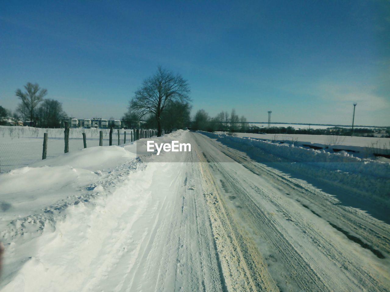 TIRE TRACKS ON SNOW COVERED LANDSCAPE