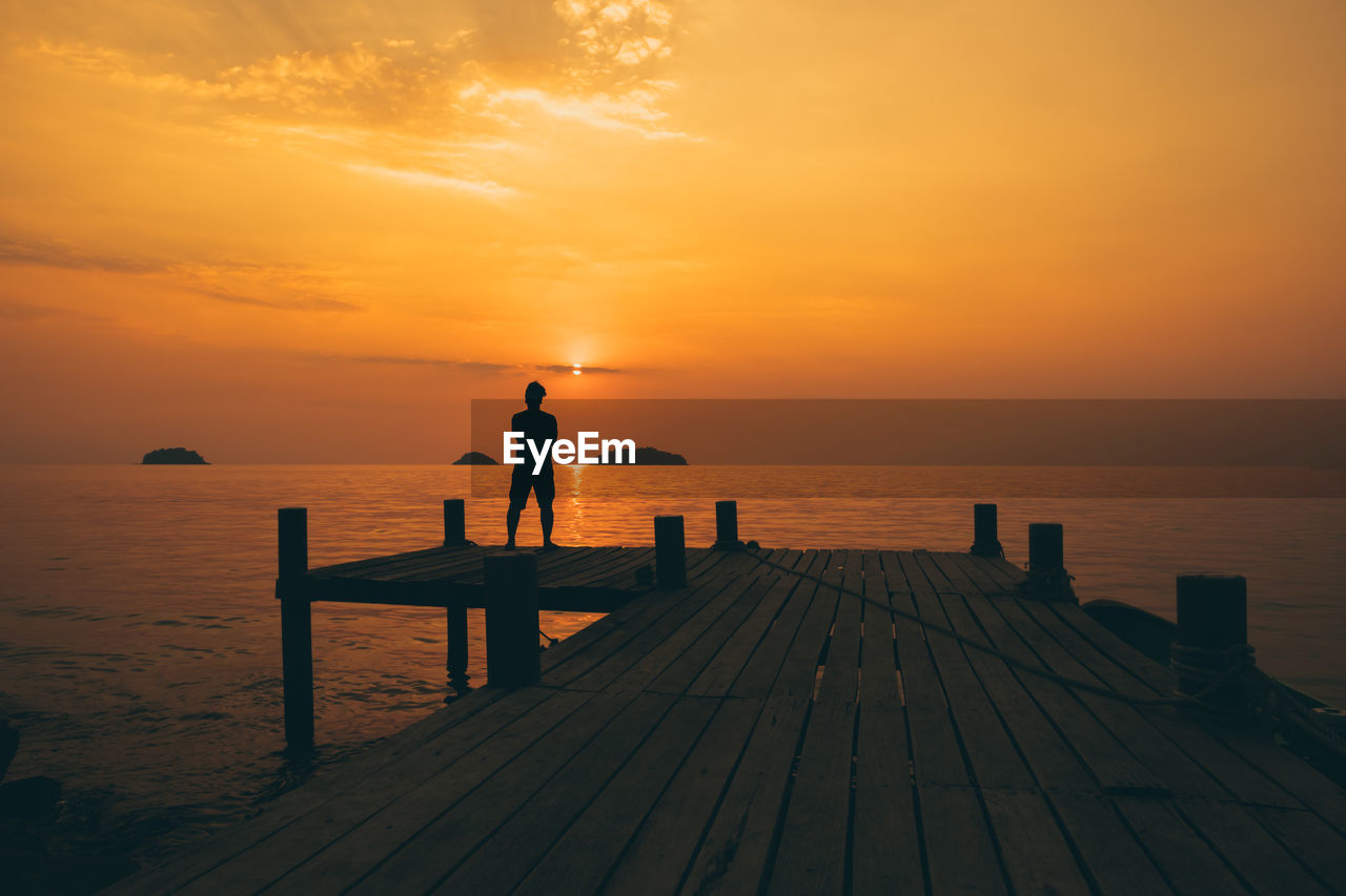 Scenic view of pier on sea against sunset sky