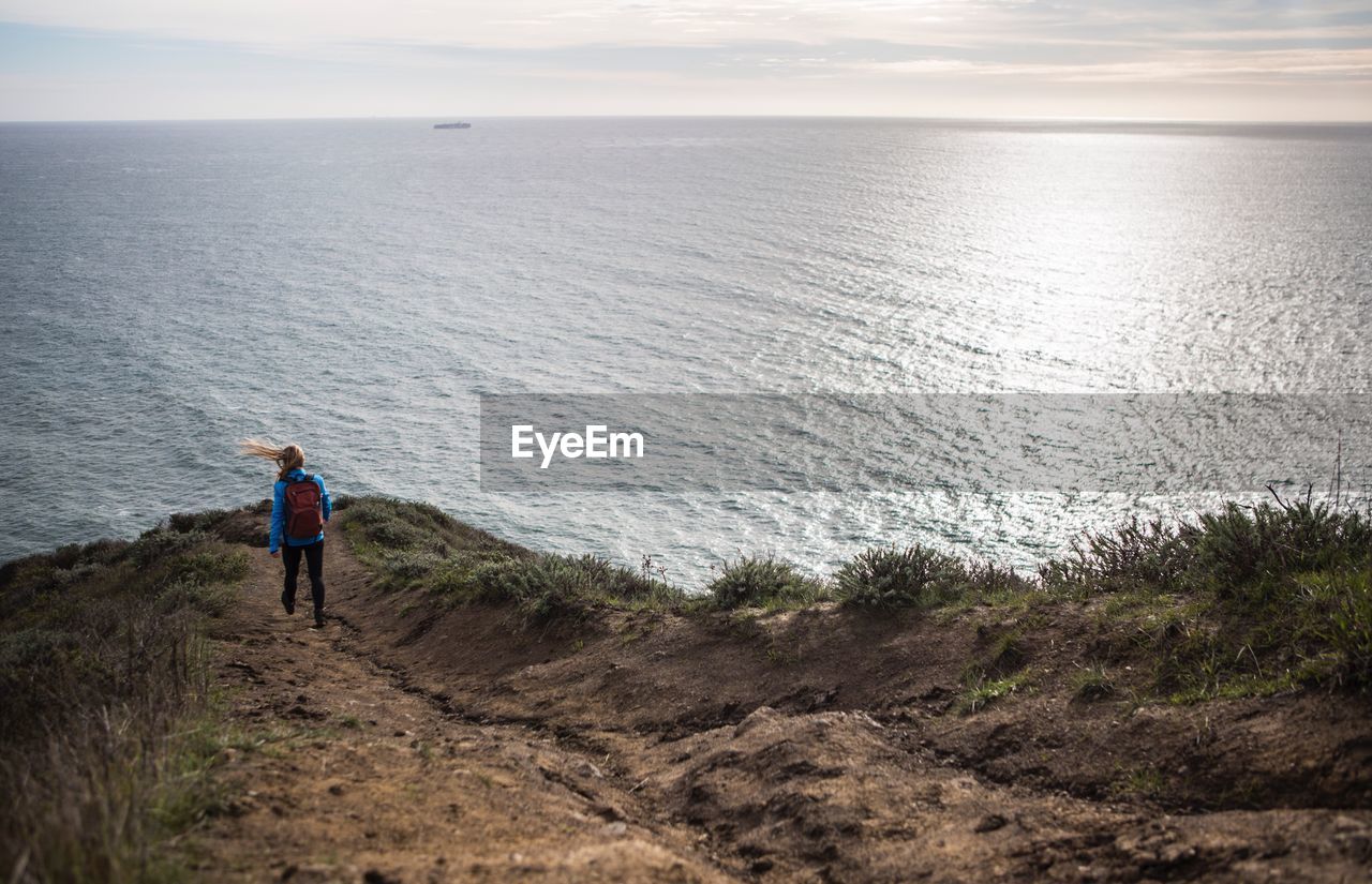 Woman walking on coastline