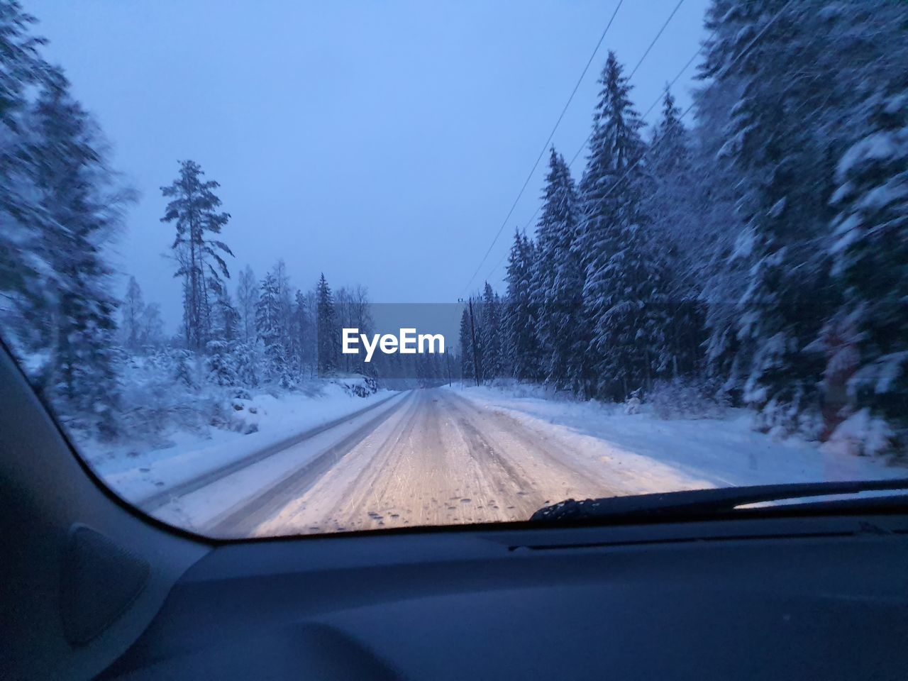 Road seen through car windshield during winter