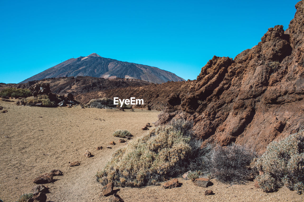 Scenic view of rocky mountains against clear blue sky