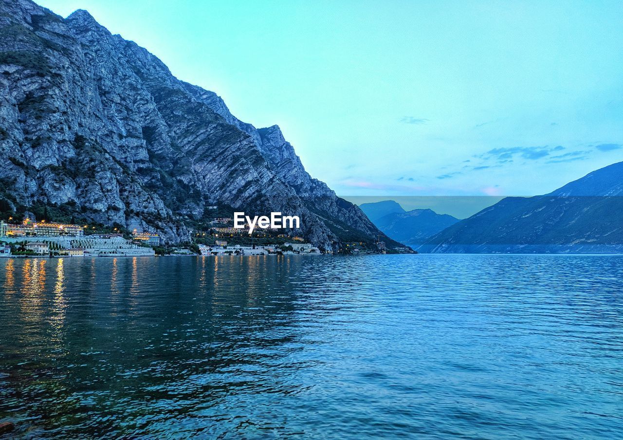 Scenic view of sea and mountains against blue sky