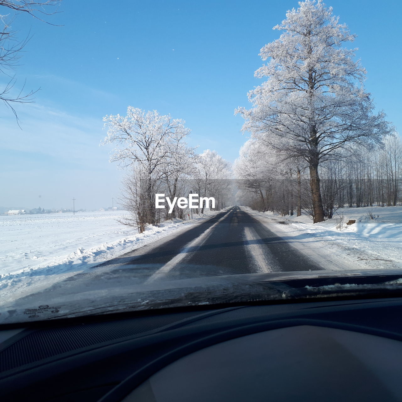 Snow covered road seen through car windshield