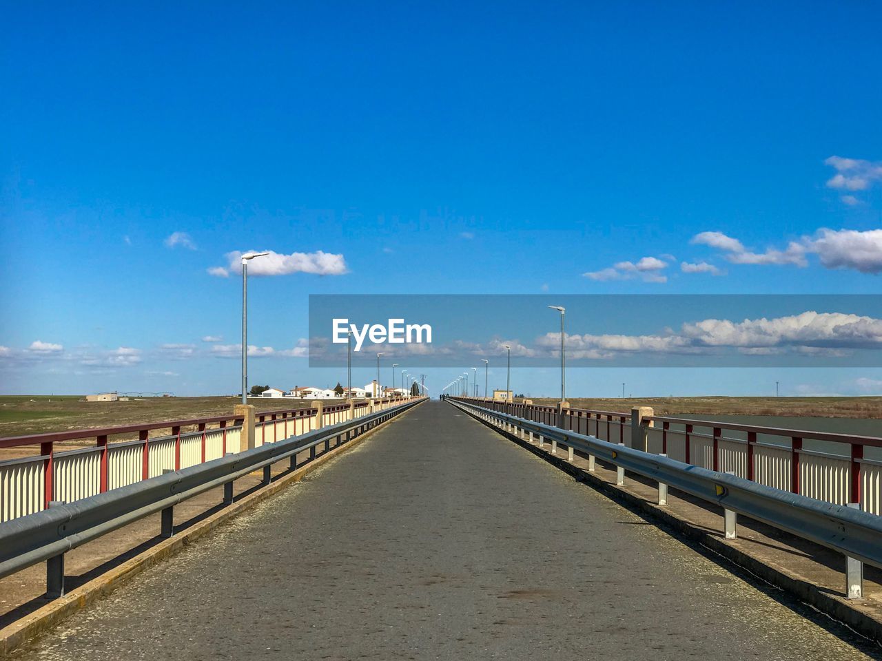 Road by bridge against sky