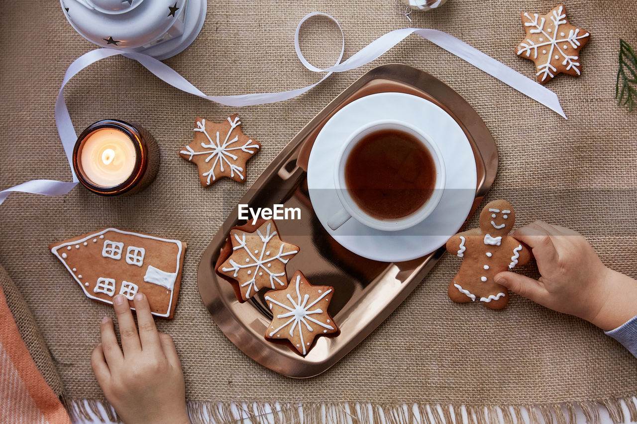 Kid takes christmas gingerbread cookies. atmospheric festive christmas decorations with hot cocoa. 