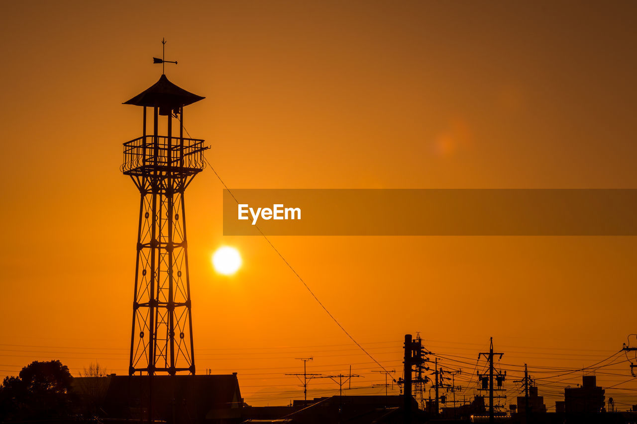 Silhouette lookout tower against sky during sunset