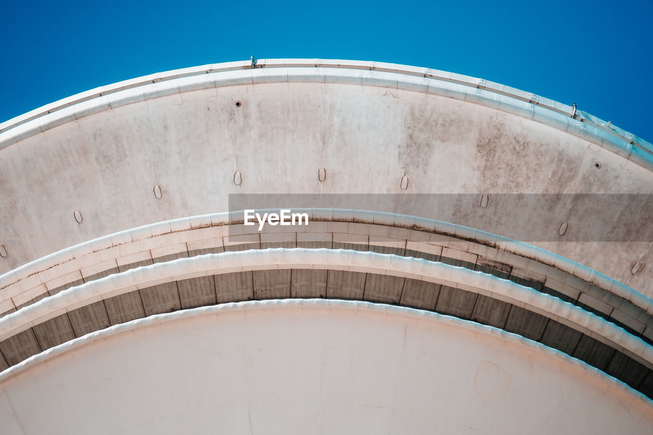 Low angle view of storage tank against blue sky