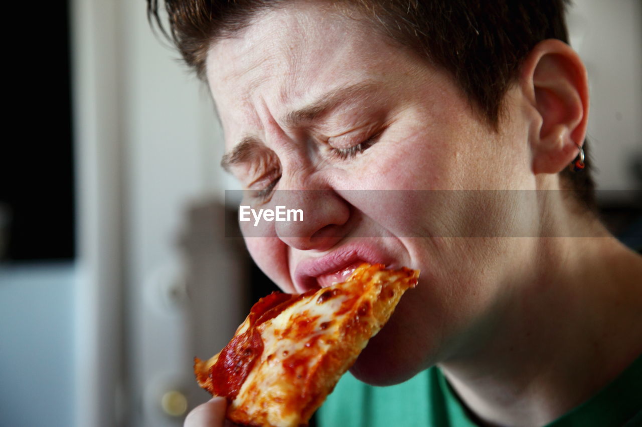 Close-up of mature woman eating pizza