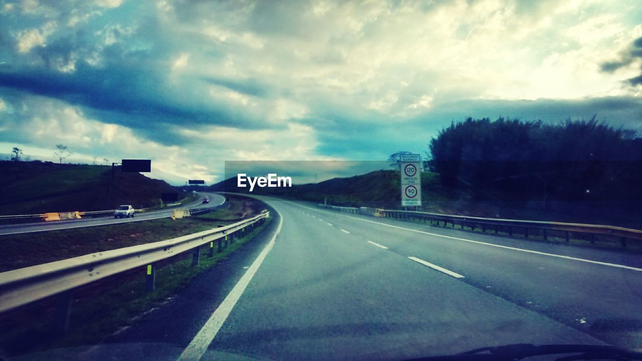 VIEW OF HIGHWAY AGAINST CLOUDY SKY