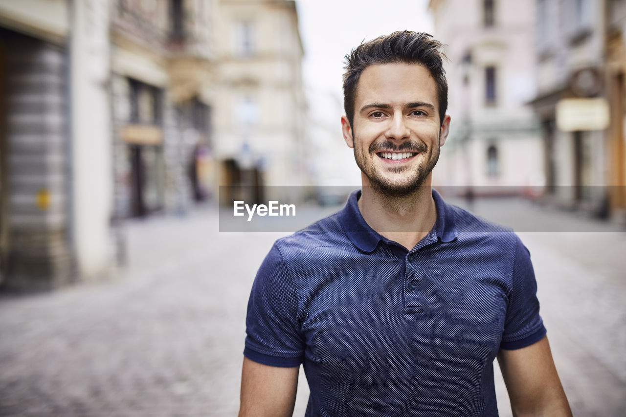 Smiling man standing on city street