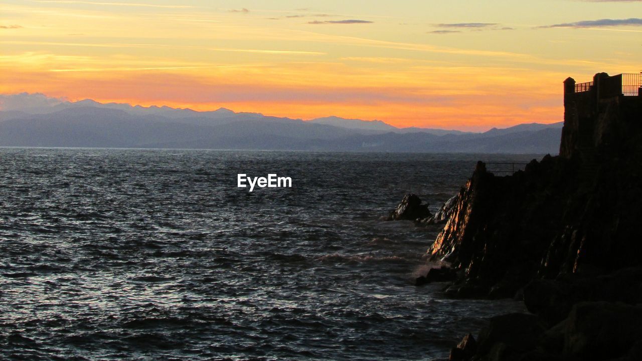 Scenic view of sea against orange sky