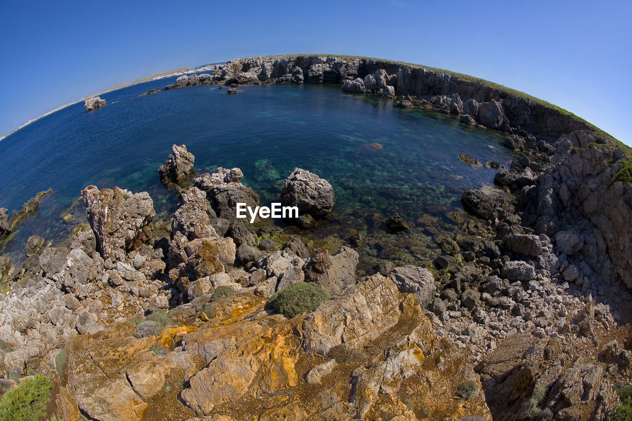 HIGH ANGLE VIEW OF SEA AND ROCKS AGAINST SKY